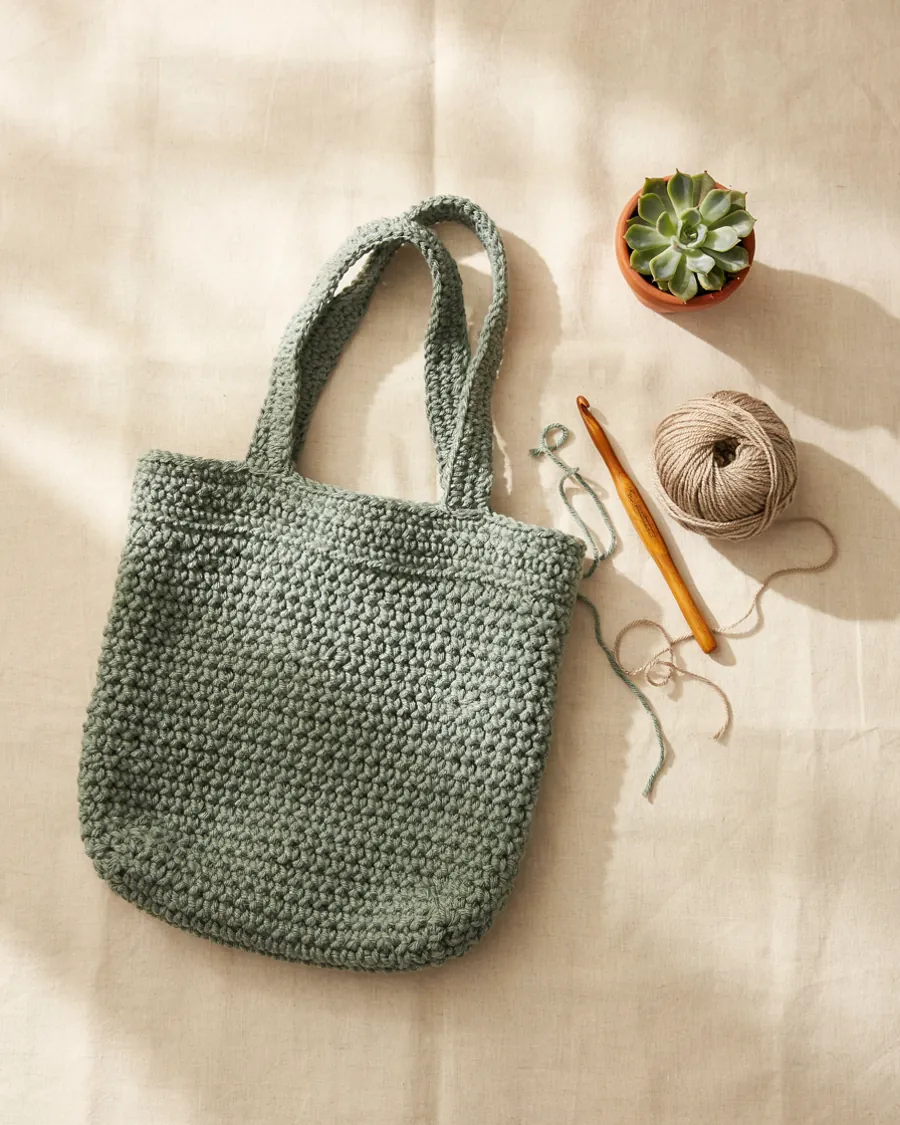 Handmade sage green crochet market tote bag with cotton yarn and wooden hook, made by this contact crochet pattern shop, MapleHookCrochet crochet bag pattern